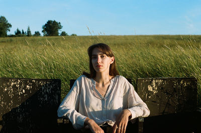 Portrait of beautiful young woman standing against plants