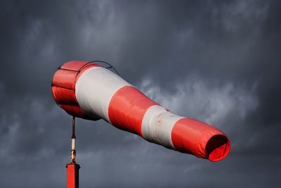 Close-up of red light against cloudy sky