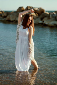 Young woman standing in sea