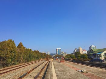 View of railroad tracks against clear blue sky