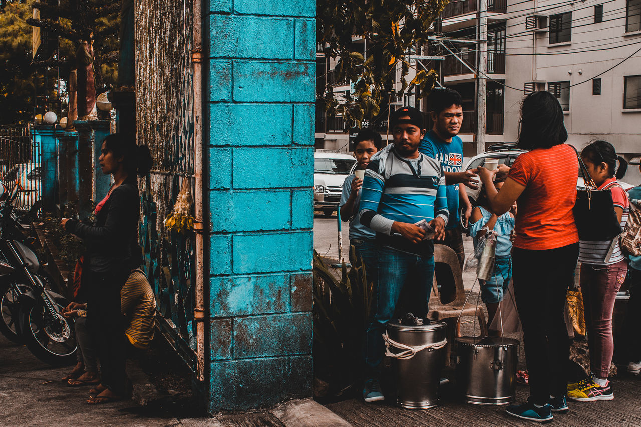 PEOPLE WORKING ON STREET AGAINST BUILDINGS