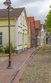 Street amidst houses and buildings against sky