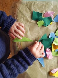 High angle view of child hand holding paper