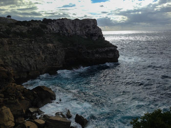 Rock formation in sea against sky