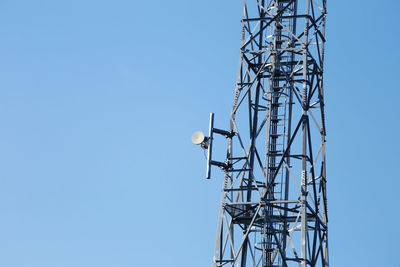 Low angle view of communications tower against clear blue sky