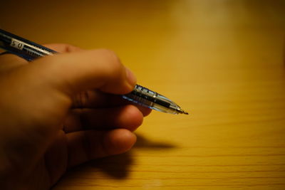 Close-up of person hand holding paper on table
