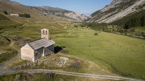 Built structure on field by mountain against sky