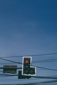 Low angle view of telephone pole against blue sky