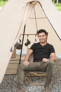 Portrait of woman sitting on tent