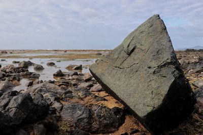 Close-up of rocks on shore against sky