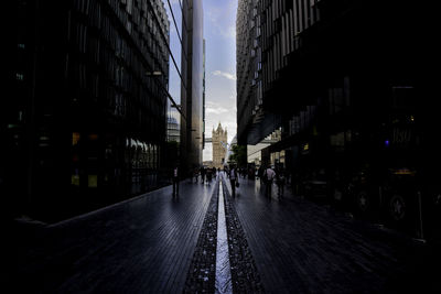 Street amidst buildings leading towards tower bridge