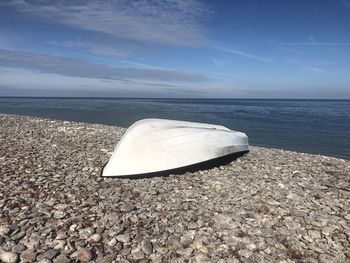 Container on beach against sky