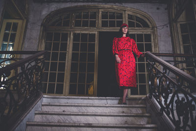 Portrait of woman standing on staircase of building