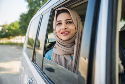 Close-up of smiling woman sitting in car