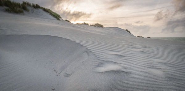 Scenic view of sand dunes against sky