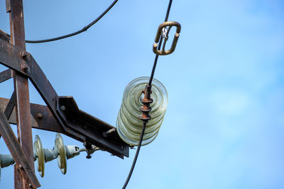 Low angle view of light bulbs hanging against sky