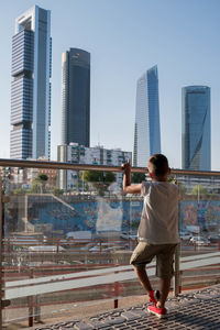 Rear view of young man standing in city