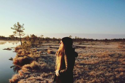 Silhouette of woman standing on landscape against clear sky