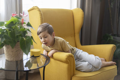 Boy using laptop while sitting on sofa at home