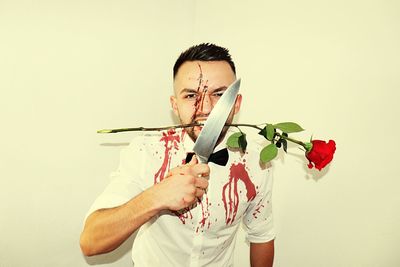 Man holding flower against white background