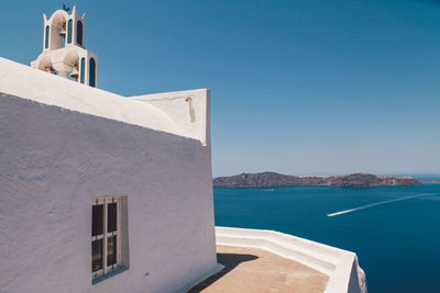 Chapel at santorini island by sea against clear blue sky