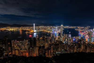 Illuminated cityscape against sky at night