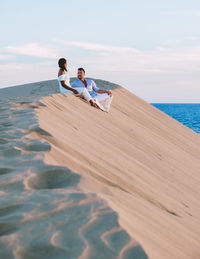 Rear view of man sitting on beach