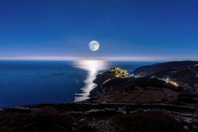 Scenic view of sea against clear blue sky at night