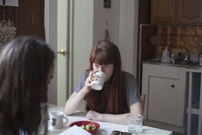 Young woman looking at her boyfriend over coffee