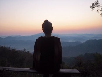 Rear view of silhouette man standing on landscape against clear sky