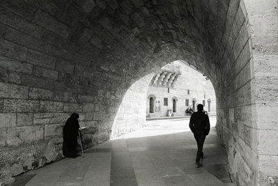 Rear view of silhouette people walking in tunnel