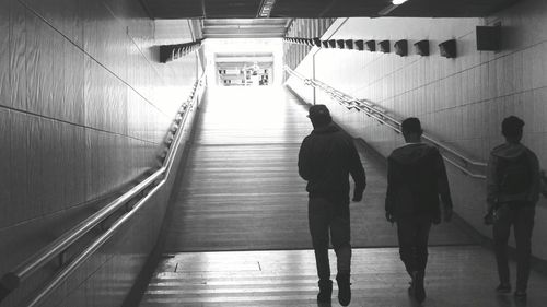 Rear view of friends walking in underground walkway