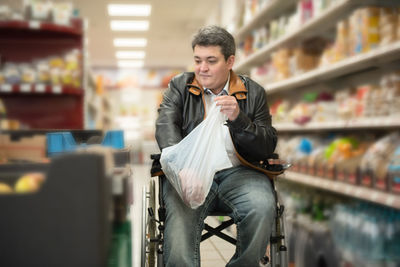 A disabled person in a wheelchair buys groceries