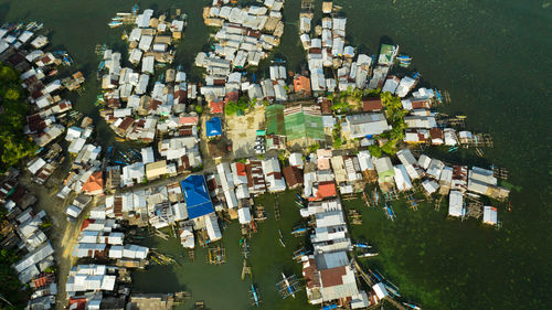 Small outrigger boat docked close to a house on stilts in a fishing villlage.  philippines, mindanao