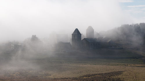 Panoramic shot of buildings on field against sky