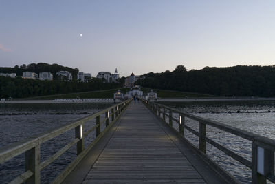 Pier over river against clear sky
