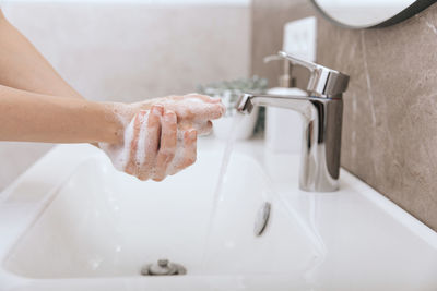 Washing hands under the flowing water tap. washing hands rubbing with soap for corona virus