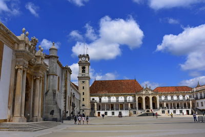 Buildings in city against cloudy sky