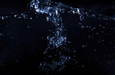 Close-up of water splashing against black background