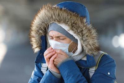 Close-up of man wearing mask coughing