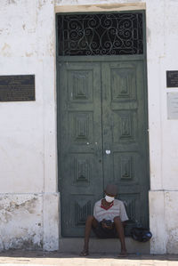 Woman sitting on window of building