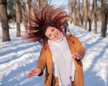 Fat caucasian woman dancing on a walk in the park in winter