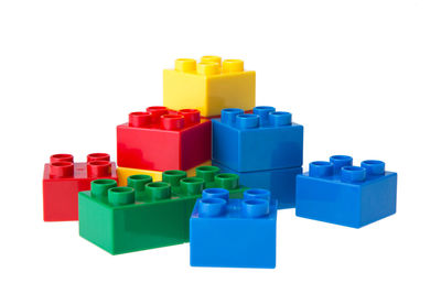 Stack of multi colored toy blocks against white background