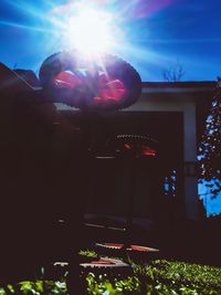 Silhouette people on illuminated building against sky on sunny day