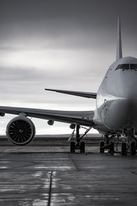 Airplane on airport runway against sky