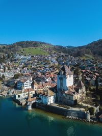 High angle view of townscape and buildings against blue sky