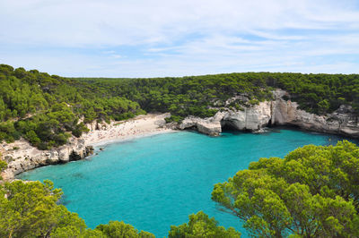 High angle view of sea surrounded by trees against sky