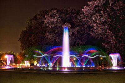 Illuminated fountain against sky at night