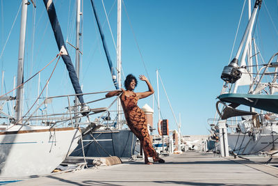 Young woman on sailboat against clear sky