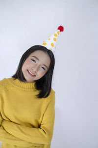 Portrait of a smiling young woman against white background